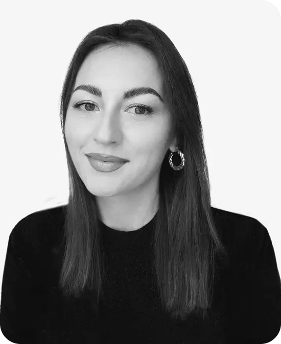 Professional headshot of a woman with straight dark hair, wearing hoop earrings and a black top.